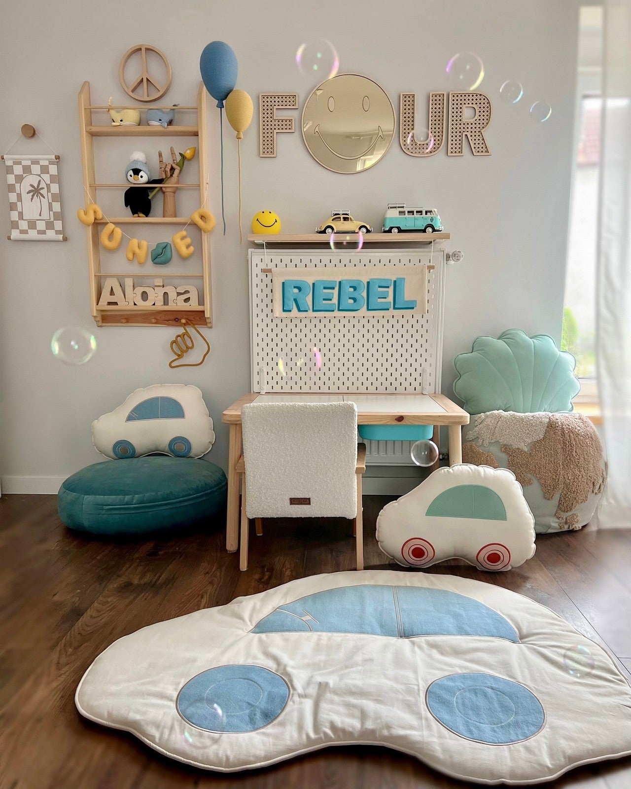Chambre d'enfant décorée avec un miroir Emoji en bois, des meubles en bois et des accessoires colorés.