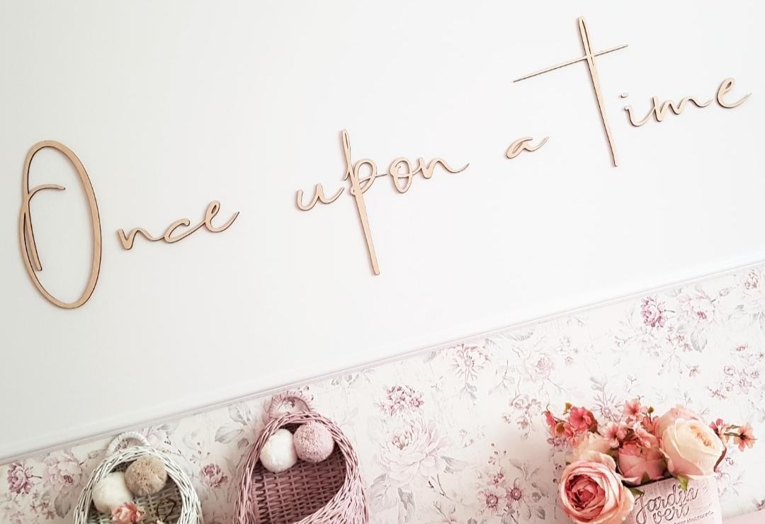 Chambre d'enfant décorée avec une inscription murale en bois « Il était une fois » dans un univers inspiré des contes.