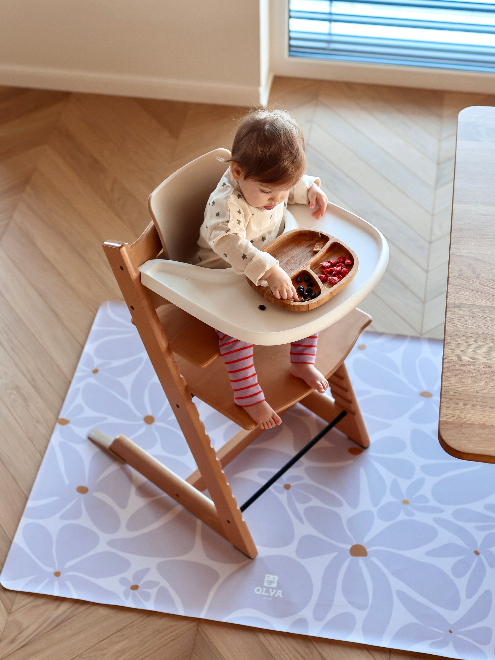 Enfant installé dans une chaise haute avec tapis de protection imperméable Daisy Lavender