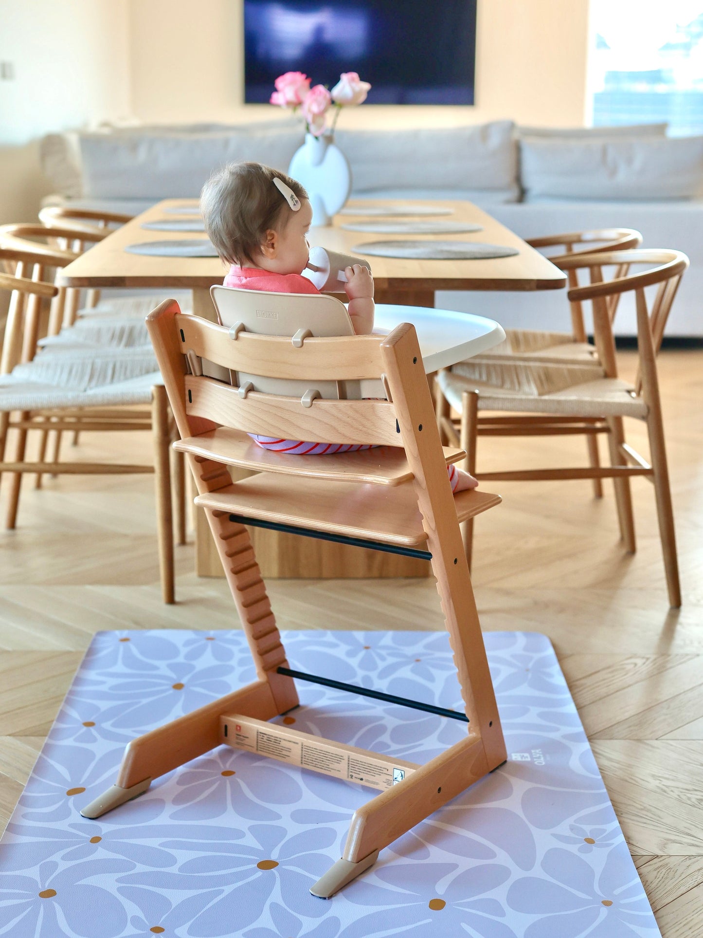 Enfant utilisant un tapis de repas imperméable sous une chaise haute en bois