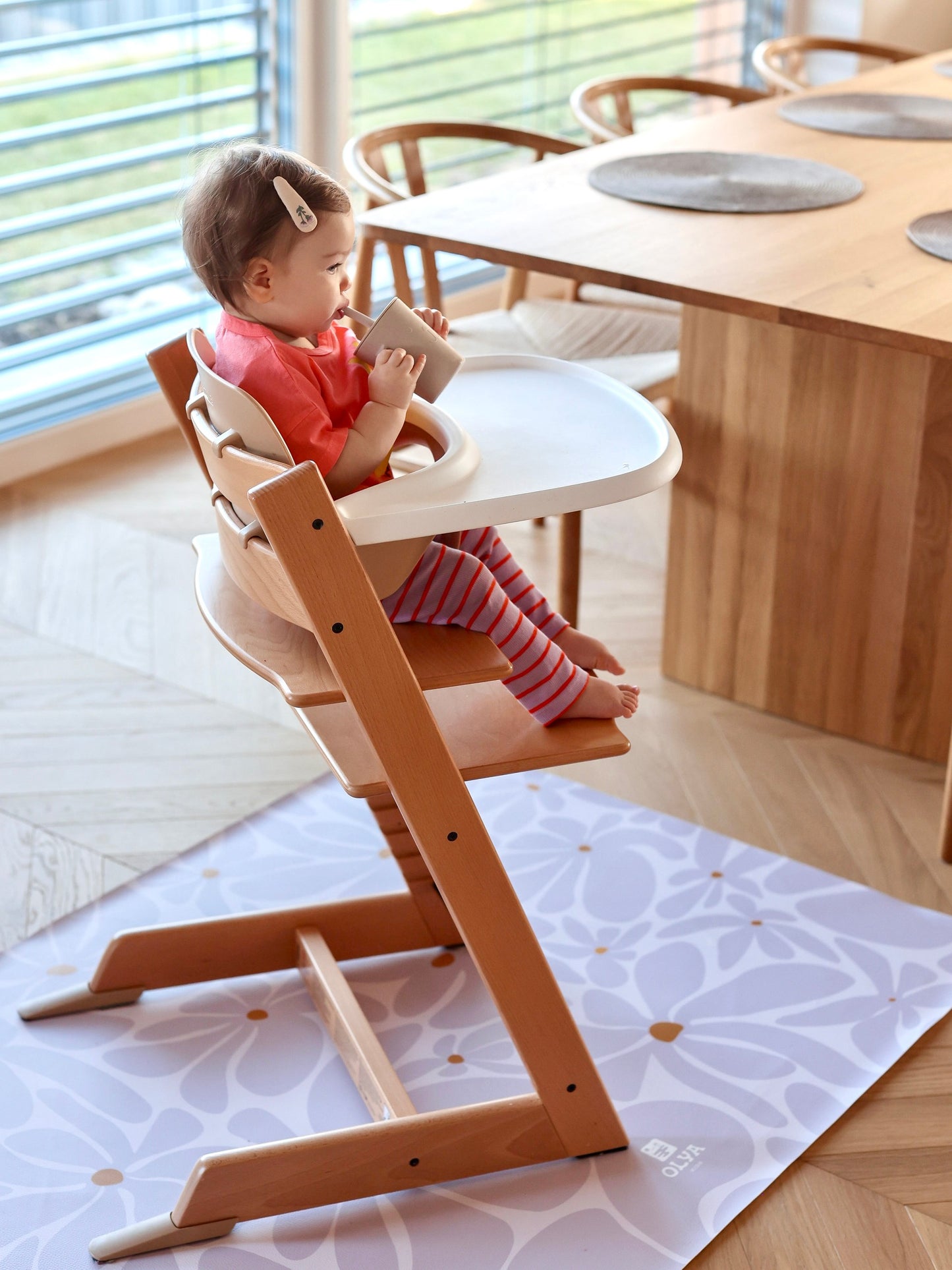 Bébé prenant son repas sur une chaise haute avec tapis de protection de sol Daisy Lavender