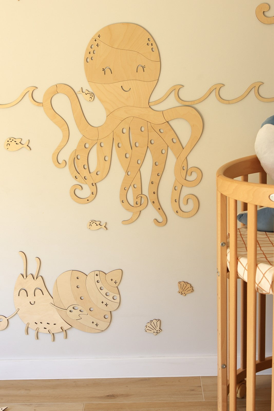 Décoration murale sur le thème de l'océan avec crabe et animaux marins en bois dans une chambre bébé.