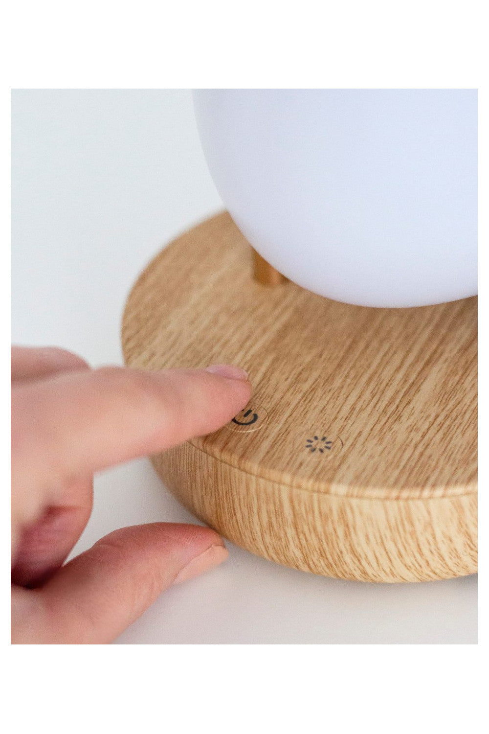 Main utilisant les commandes tactiles de la veilleuse oiseau avec enceinte