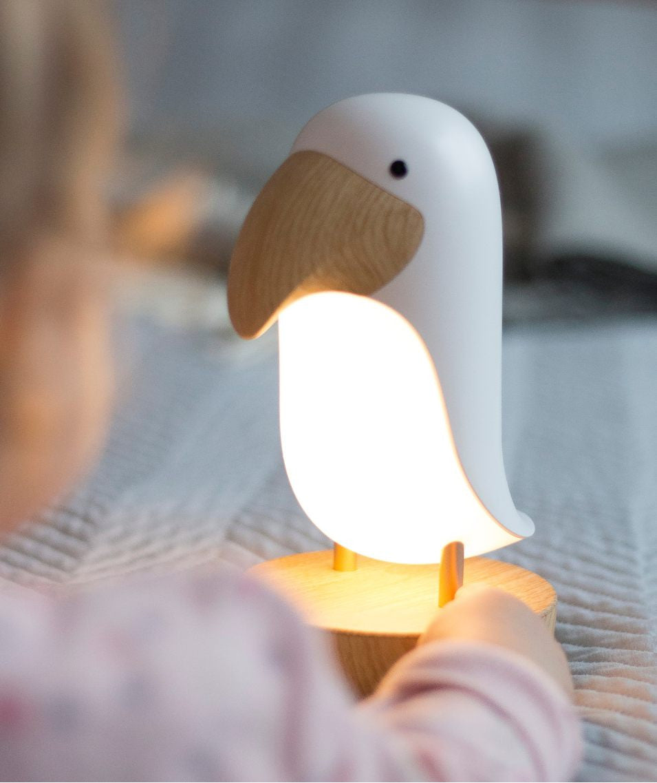 Veilleuse oiseau blanc avec enceinte Bluetooth diffusant une lumière douce dans une chambre bébé